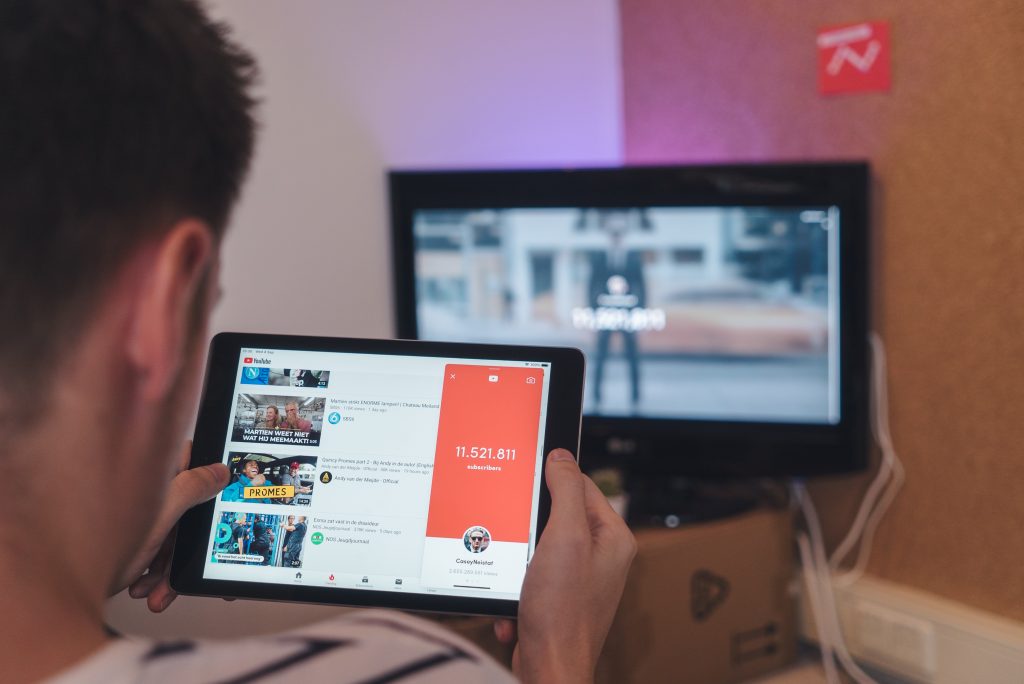 man with tablet and TV in the background symbolizing a consumer trend - convenience