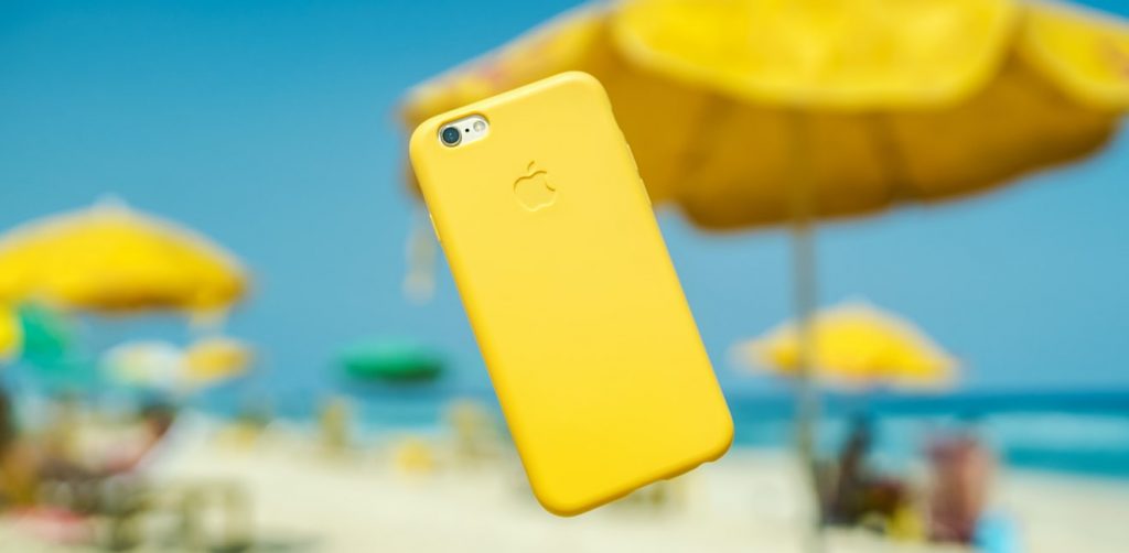iPhone with yellow case on beach background